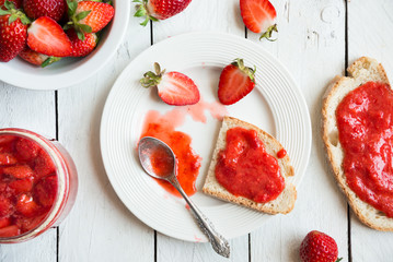 Homemade strawberry jam with fresh fruit on white