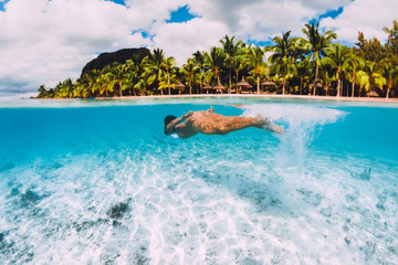 Young attractive woman swimming underwater in transparent ocean. Mauritius, Le Morne