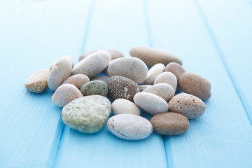Fototapeta na wymiar Pile of white stones on a blue wooden table