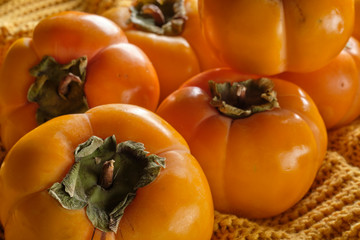 Persimmons on orange knitwear surface