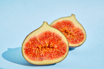 Fresh sliced figues on light blue background
