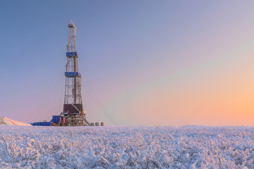 In a winter snow-covered tundra, a well is being drilled at an oil and gas field. Polar day....