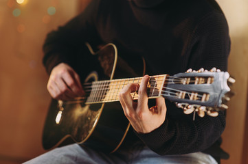 Fototapeta premium the guy plays the guitar. close-up of hands