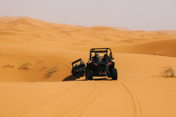 Off road buggies crossing dunes in the desert. Rally raid adventure.