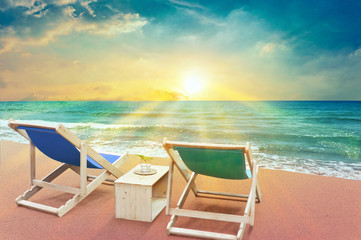 two beach chairs on sunset time and scenery sea view with beautiful sun rays , summer concept