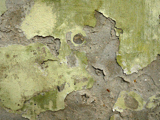 Old cement wall of a building with cracked paint. Aged background and texture