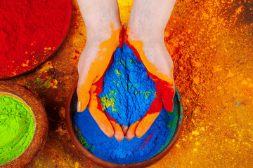 Hands holding Holi powder paint, view from above