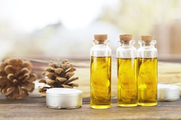 Essence of flowers and herb in a beautiful glass jar on wooden background.