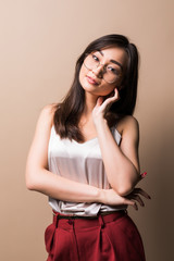 Charming asian woman standing isolated over beige background