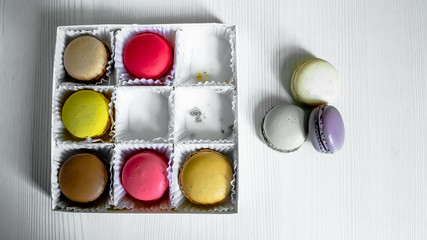 White pack with Macarons cookie, on a white wooden background. View from above. Copy space