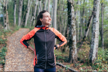 Young white woman in a tracksuit in a forest park. Preparation for sports training and jogging.