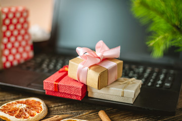 Obraz na płótnie Canvas Gift boxes on the laptop. Purchase discounts for the new year in online stores on Christmas eve