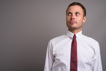 Portrait of handsome businessman against gray background