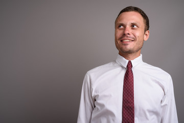 Portrait of handsome businessman against gray background