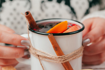Hot muilled wine in woman's hands close up