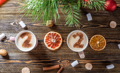 Card with numbers 2020 for New year and Christmas. Cup of coffee with figures on wooden background. Top view. Flat lay