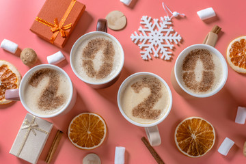 Card with numbers 2020 for New year and Christmas. Cup of coffee with figures on pink background. Top view. Flat lay
