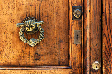 vintage door knocker on old wooden door. Rome