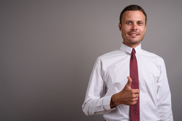 Portrait of handsome businessman against gray background