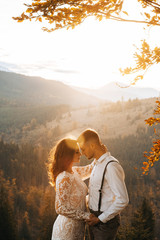 Tender groom hugging happy bride in sun light, romantic moment