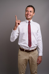 Portrait of handsome businessman against gray background