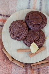 Fototapeta premium chocolate cookies on wooden plate, decorated with cinnamon and autumn leaf