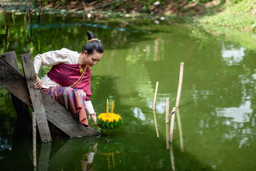 Beautiful woman ware Traditional Thai dresses hold floating basket or kratong, loy kratong festival in Thailand