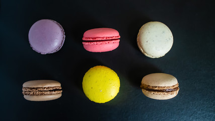 Macaroons cookies on a dark canvas background. view from above.