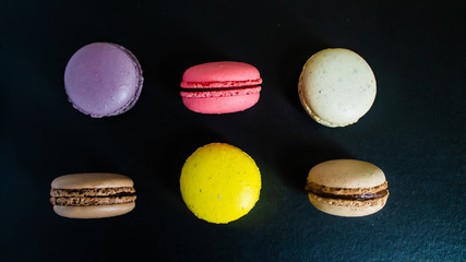 Macaroons cookies on a dark canvas background. view from above.