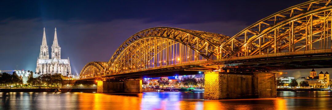 Panorama of the Hohenzollern Bridge over the Rhine River and Cologne Cathedral by night