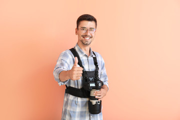 Young male photographer on color background