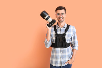 Young male photographer on color background