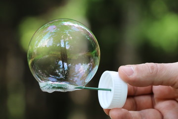 Close-up of the soap bubble that holds the hand