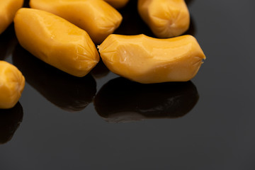 Pile of raw sausages isolated on black background with copy space text