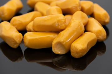 Pile of raw sausages isolated on black background with shadow