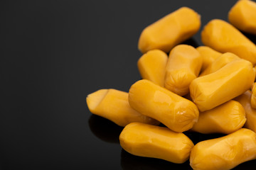 Pile of raw sausages isolated on black background with copy space text