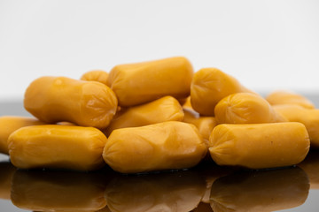 Pile of raw sausages isolated on black background with shadow