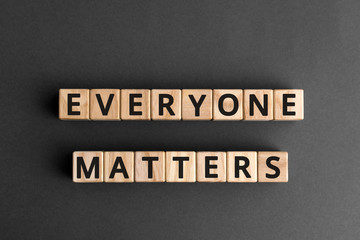 Everyone matters - phrase words from wooden blocks with letters, accepting others individuality everyone matters concept, top view gray background