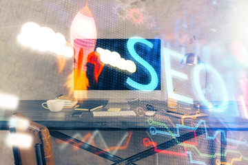 Multi exposure of table with computer and seo drawing hologram. Search optimization concept.