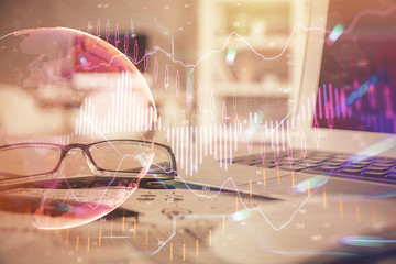 Financial chart hologram with glasses on the table background. Concept of business. Double exposure.