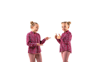 Young handsome girl arguing with herself on white studio background. Concept of human emotions, expression, mental issues, internal conflict, split personality. Half-length portrait. Negative space.