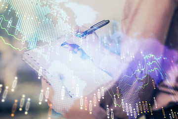 Multi exposure of hands making notes with forex chart huds. Stock market concept.