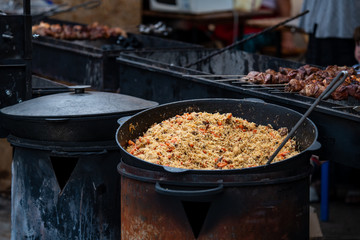 Cauldron with pilaf or pilau rice dish on street food fest 