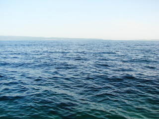 Obraz premium Natural pattern of diversity of shades of sea blue at sunset on the background of the evening sky.