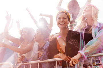 Audience With Colored Smoke Behind Barrier Dancing And Singing At Outdoor Festival Enjoying Music