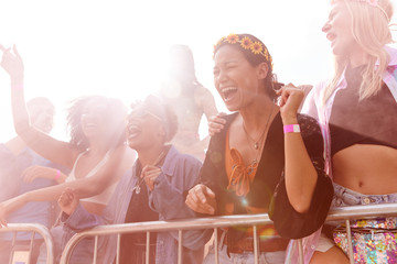 Audience With Colored Smoke Behind Barrier Dancing And Singing At Outdoor Festival Enjoying Music