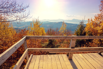 Autumn in the mountains. Panoramic view of the mountains and the valley in autumn from the wooden balcony. Beautiful nature landscape. Carpathian mountains. Bukovel, Ukraine