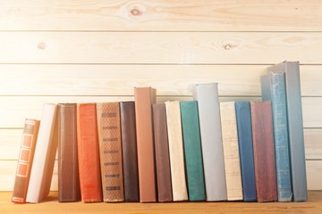 Ancient books in a row on wooden background