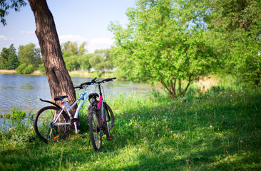 two bicycles stand on the Bank of the river