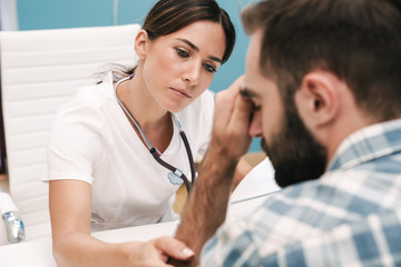 Doctor talking with her stressed sad patient